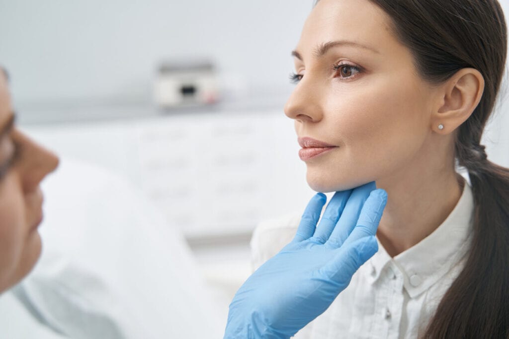 Preparing for Botox and dermal fillers - Woman’s face being examined by a dermatologist.