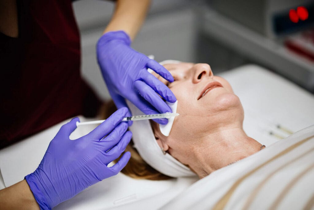 Botox and dermal fillers - A mature woman in a clinic getting a Botox procedure from a trained skin professional.