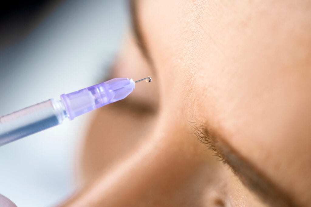 A cropped photo of a woman receiving dermal filler treatment