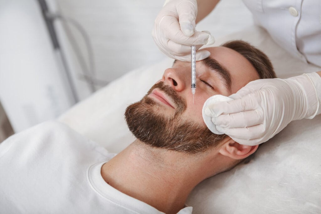 Man getting injected by fillers as he closes his eyes
