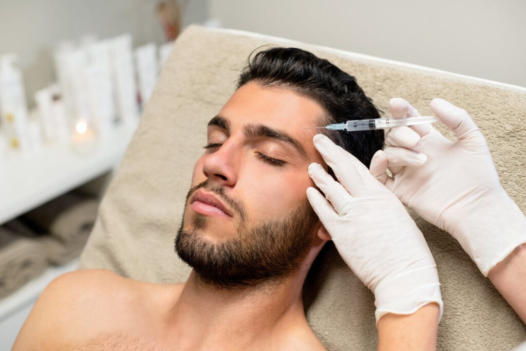 Injecting Botox during the treatment of a male client