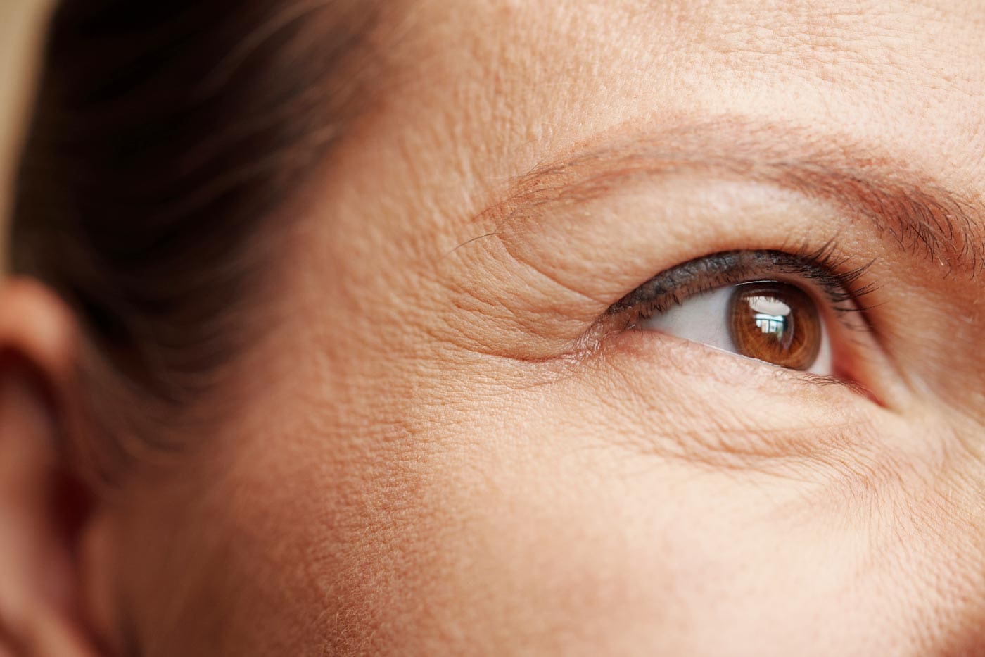 Close-up of female face showing crow's feet and fine lines around the eyes