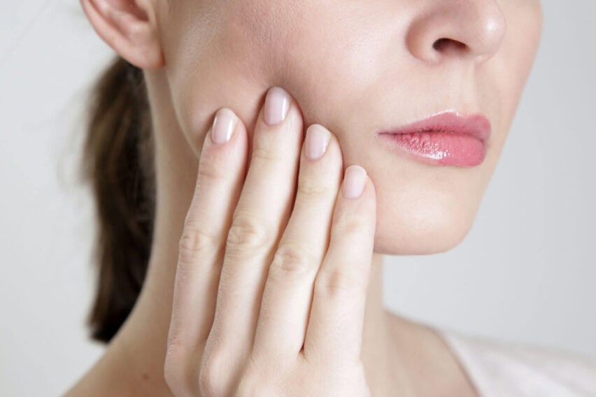 Close up of female with jaw pain and jaw tension